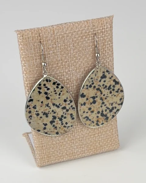 Dalmatian Jasper Slice Earrings hanging on a linen earring display