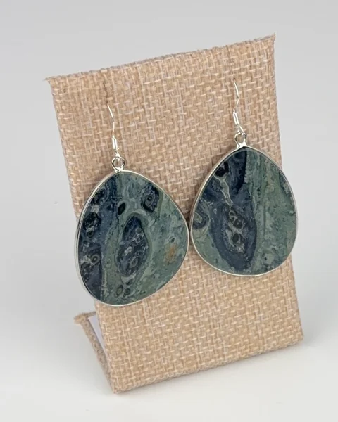 Kambaba Jasper Slice Earrings hanging on a linen earring display